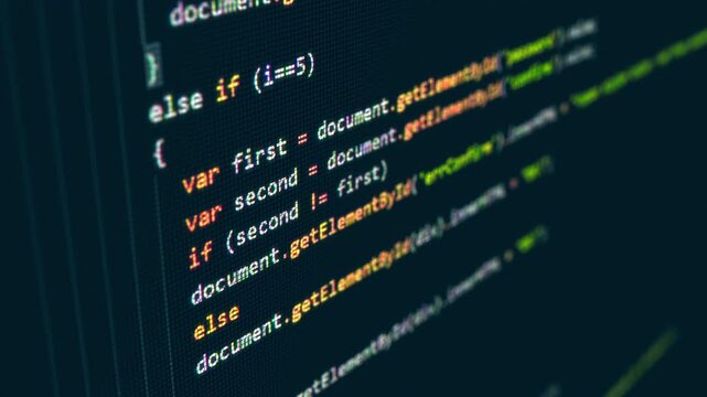 Lines of script on a monitor as a developer writes a web page. Colored syntax close to the glass of the screen. Programming work at night