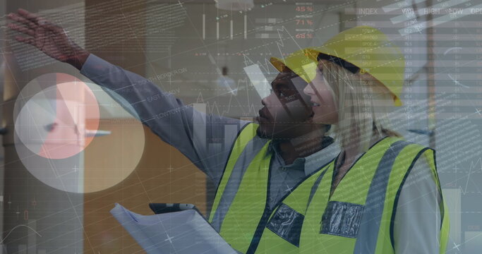 Engineers in safety vests and helmets discussing project plans at construction site