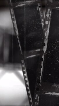 Vertical video: Blurred finger entering lower left, two 35mm strips rotating crossing for scanning