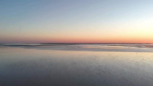 Aerial view of Wadden Sea mudflats in North Frisia during colorful sunset, Schleswig-Holstein, Germany, Europe. Mudflats in North Frisia reflecting the glowing sunset sky during low tide, Schleswig-Ho