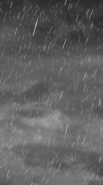 Vertical video: Cloud bands driving rain, raindrop streaks falling diagonally showing ongoing storm