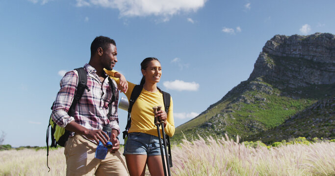African american couple walking while trekking in the mountains