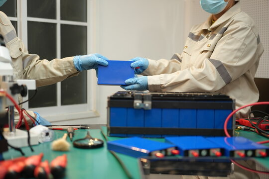 The skilled technician works on the lithium phosphate battery circuit board with his partner.