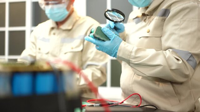The skilled technician works on the lithium phosphate battery circuit board with his partner.