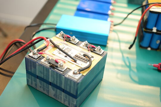The skilled technician works on the lithium phosphate battery circuit board with his partner.