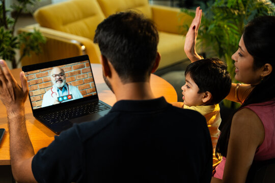 Indian Couple with Baby Using Laptop for Telemedicine Consultation at Home