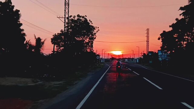 Scenic asphalt road stretching toward a bright sunset on the horizon highway sun sky travel transportation
