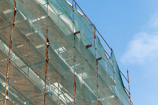 Blue sky behind green construction netting