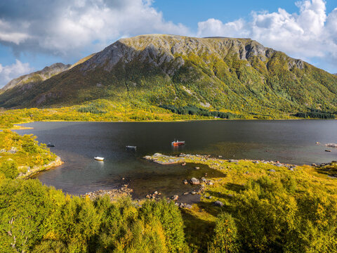 Scenic fjord with small boats and autumn mountains in the Lofoten Islands