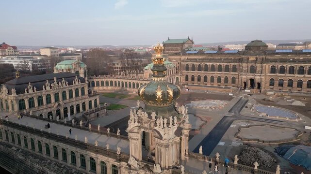 Aerial drone flight over historic Dresden Germany showcasing the magnificent Baroque Zwinger Palace and its golden Kronentor Crown Gate a masterpiece of European architecture during daytime
