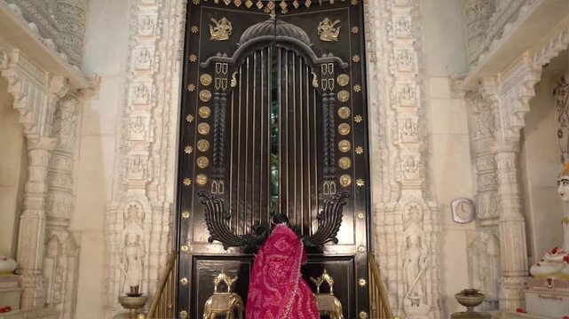 Opening the Ornate Inner Door of a Jain Temple to Reveal Sacred Idols of Shri Parshvanath Bhagwan and Other Jain Tirthankars During Religious Worship