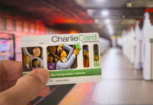 Boston, USA. October 24, 2026, Hand holding a CharlieCard fare card over a Boston MBTA subway platform, representing public transit access, daily commuting, and urban travel