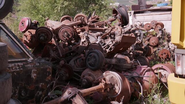 Pile of Rusted Auto Mechanical Scrap Parts Axles Suspension and Brake Drums in Scrapyard