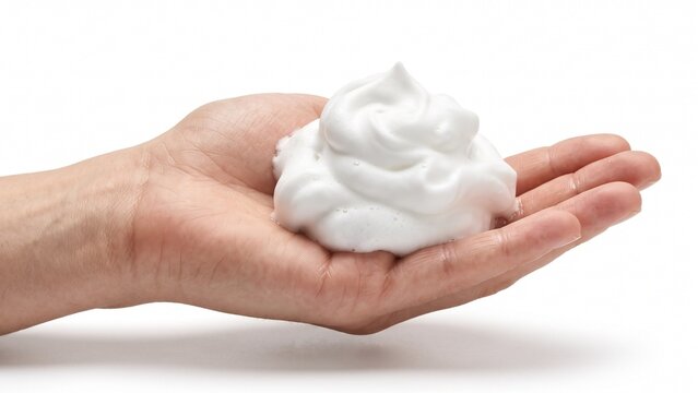 Fluffy white shaving foam resting delicately inside an open human hand on white background