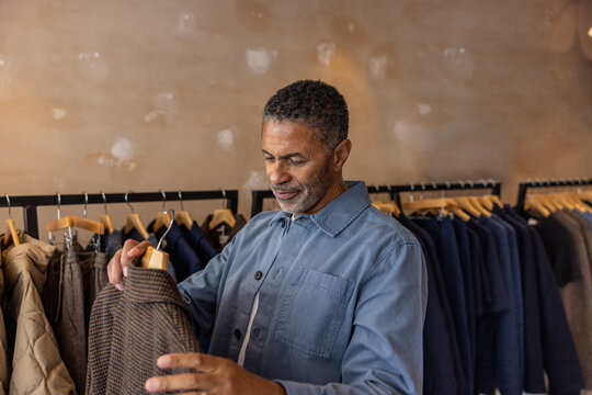 Senior Man Examining Jacket in Clothing Store