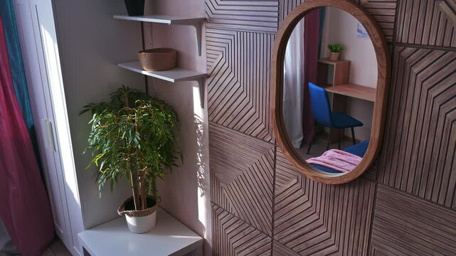 Stylish entryway with oval wooden-framed mirror, geometric wall panels, white floating shelves, potted green plant, clean modern aesthetic.
