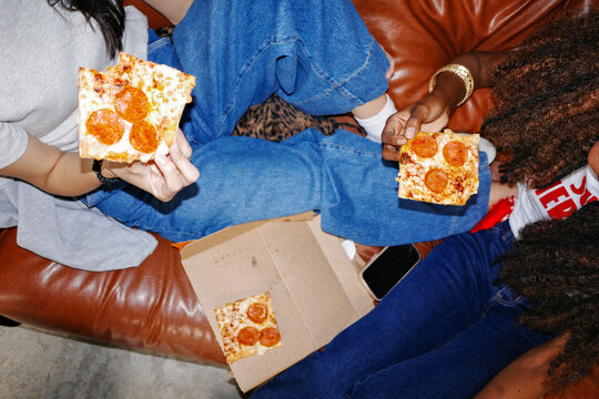 Friends sharing pizza slices together overhead view