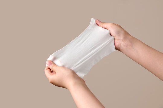 Hands stretching a thin white fabric material to show its