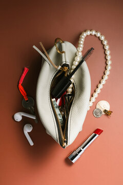 Overhead shot of leather handbag filled with personal accessories