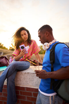 Young diverse students using smartphones on campus