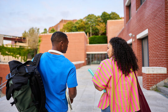 University students walking on campus discussing education