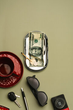 Money and burnt match in silver plate with daily objects