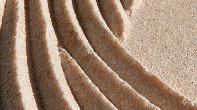 Macro texture of carved parallel grooves in beige sandstone under hard light, with generous copy space