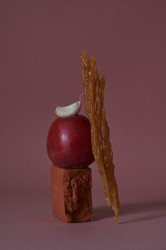 An abstract composition with melted wax, clay and an apple