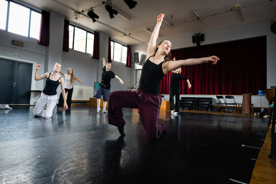 Group dance class with lead dancer in lunge