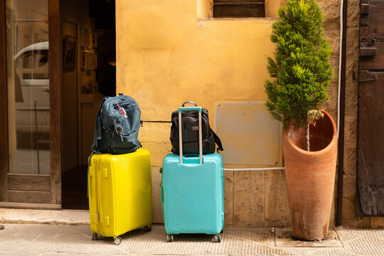 Two bright cases wait beside a hotel doorway