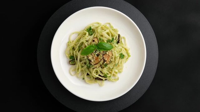Linguine pasta with broccoli pesto sauce and fresh shiitake mushrooms in white plate.Top view.