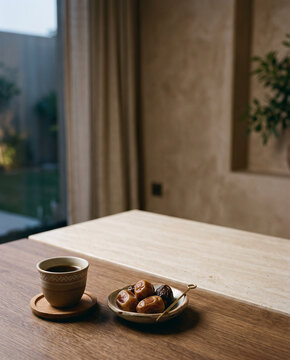 Dates and a small coffee cup on a wooden table