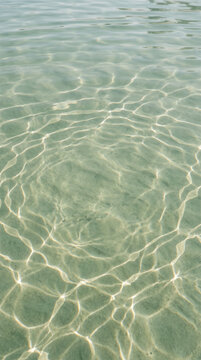 Sunlight patterns on pale green rippling water