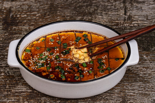Chinese steamed egg custard closeup in dish. Traditional asian steamed egg pudding with soy sauce, sesame oil and green onions. Savory egg custard slice in ceramic bowl with wooden chopsticks