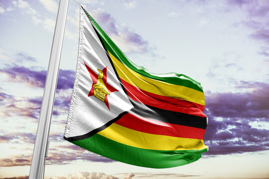 Zimbabwe flag waving on flagpole against cloudy sky