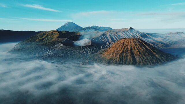 A bird's-eye view of the eruption of Bromo volcano at dawn in Bromo-Tengger-Semeru National Park, East Java, Indonesia. The caldera of Tengger volcano is hidden by clouds and fog. Dron.4K