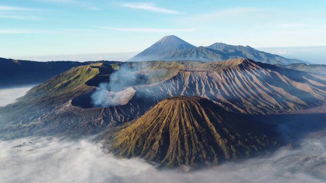 A bird's-eye view of the eruption of Bromo volcano at dawn in Bromo-Tengger-Semeru National Park, East Java, Indonesia. The caldera of Tengger volcano is hidden by clouds and fog. Dron.4K