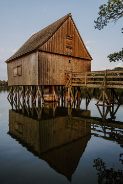 Stilt hut reflection at golden hour, vertical