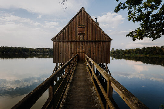 Wooden walkway to stilt hut over pond