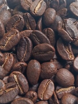 Close-Up of Dark Roasted Coffee Beans Pile With Golden Cracks