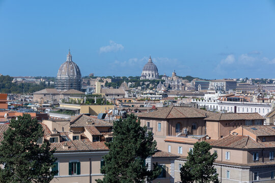 Rome skyline with St Peter's Basilica dome and terracotta rooftops under a clear blue sky, Italy