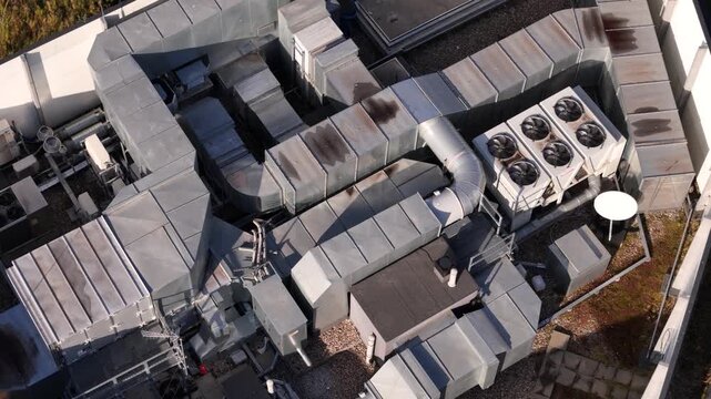 Commercial rooftop ventilation equipment functioning atop an urban industrial building