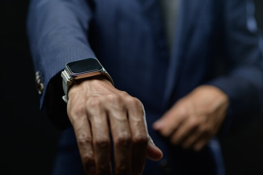 Businessman Showing Smartwatch on Wrist in Formal Suit in Office Setting