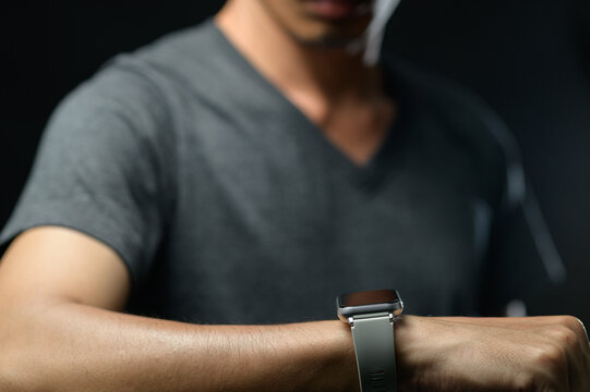 Man Wearing Smart Watch on Wrist Checking Time or Notifications in Dark Environment