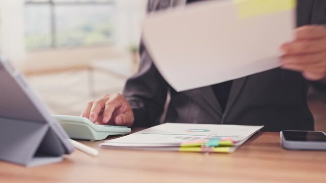 Businessman calculates financial budget review documents at desk. Corporate audit tax analysis, investment portfolio accounting examination, commercial revenue report evaluation.