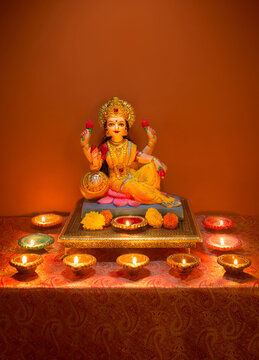 Beautiful statue of Goddess Laxmi with plenty of lit up Diyas. Diwali festival photo with glowing oil lamps and Lakshmi idol. Indian religious festivals photos.