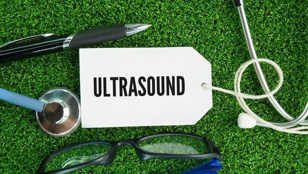 Stethoscope, pen and paper tag with the words ultrasound sonography is a non-invasive medical imaging test that uses high-frequency sound waves greater than 20 kHz to create real-time pictures or vide