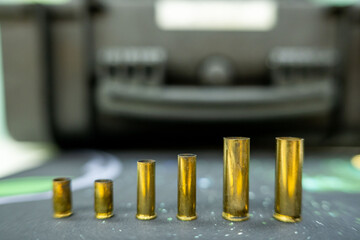 Six empty brass cartridge cases in a row arranged by size © bevisphoto