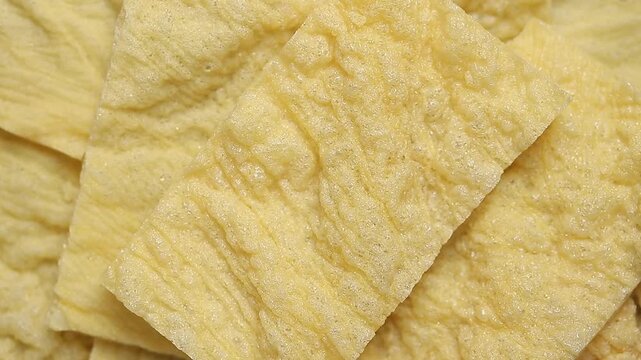 pile of crispy fried bean curd skin sheets slowly rotating. Top view shot