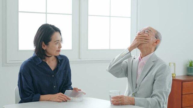 高齢男性に薬を飲ませる女性